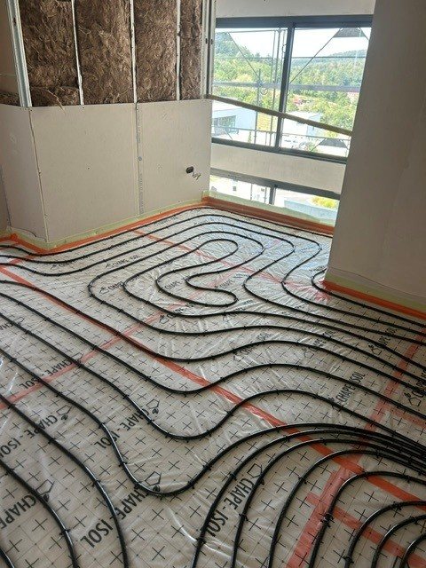 Boucles de plancher chauffant posées dans une pièce de vie à Ferrette
