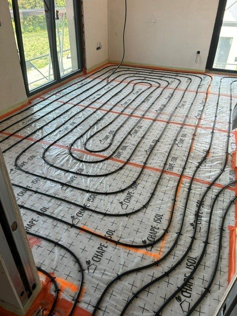 Réseau de plancher chauffant dans le séjour d’une maison à Ferrette