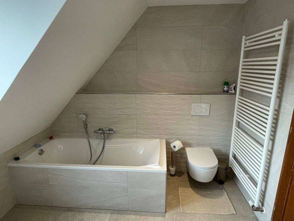 Après rénovation : baignoire encastrée sous rampant et carrelage grand format