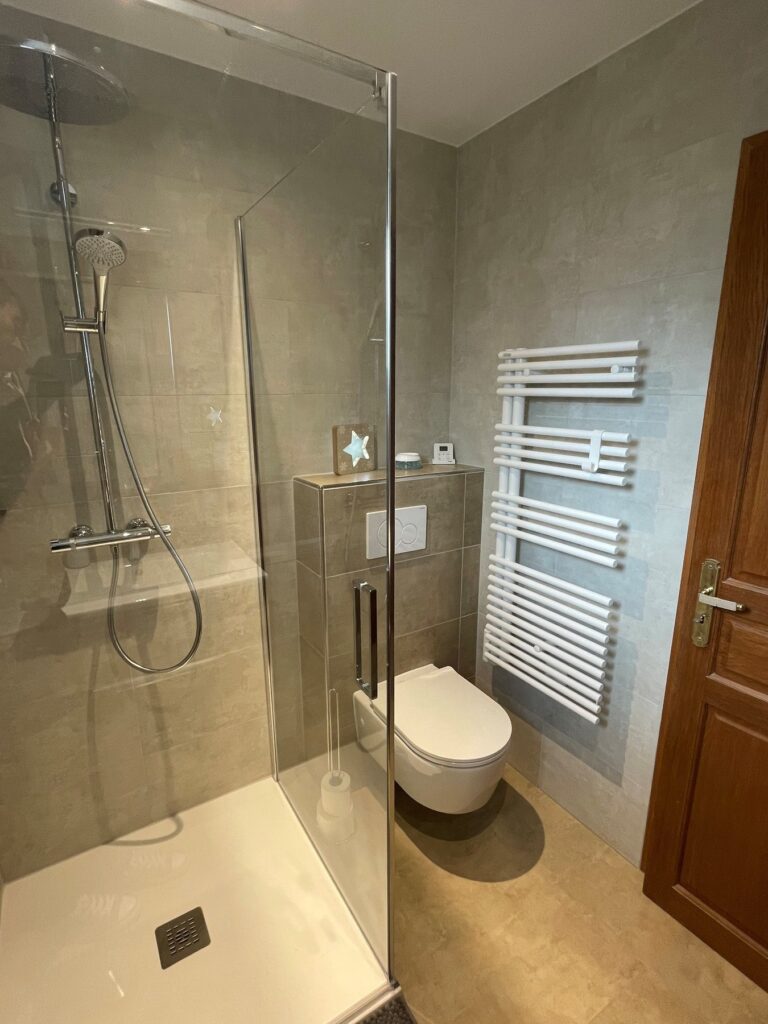 Après rénovation : douche à l’italienne avec paroi vitrée et WC suspendu
