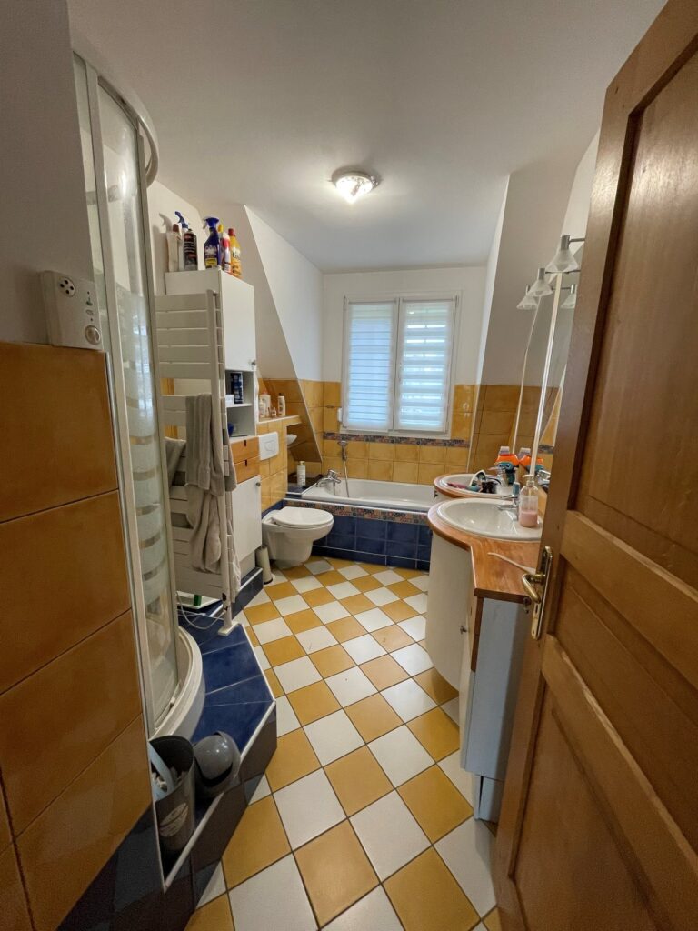 Avant rénovation : salle de bains au carrelage damier et cabine de douche