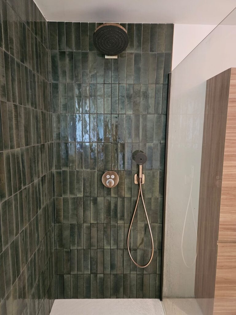 Douche à l’italienne habillée de zellige vert dans une salle de bains rénovée