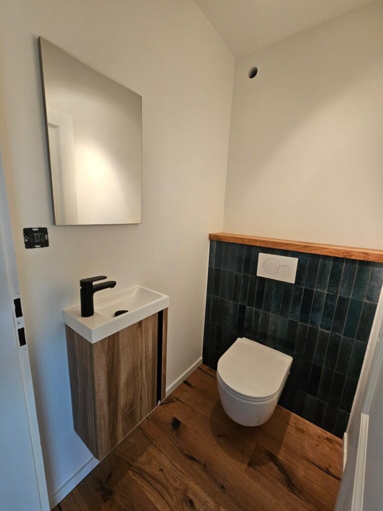 WC suspendu et plan lave-mains bois dans une salle de bains rénovée